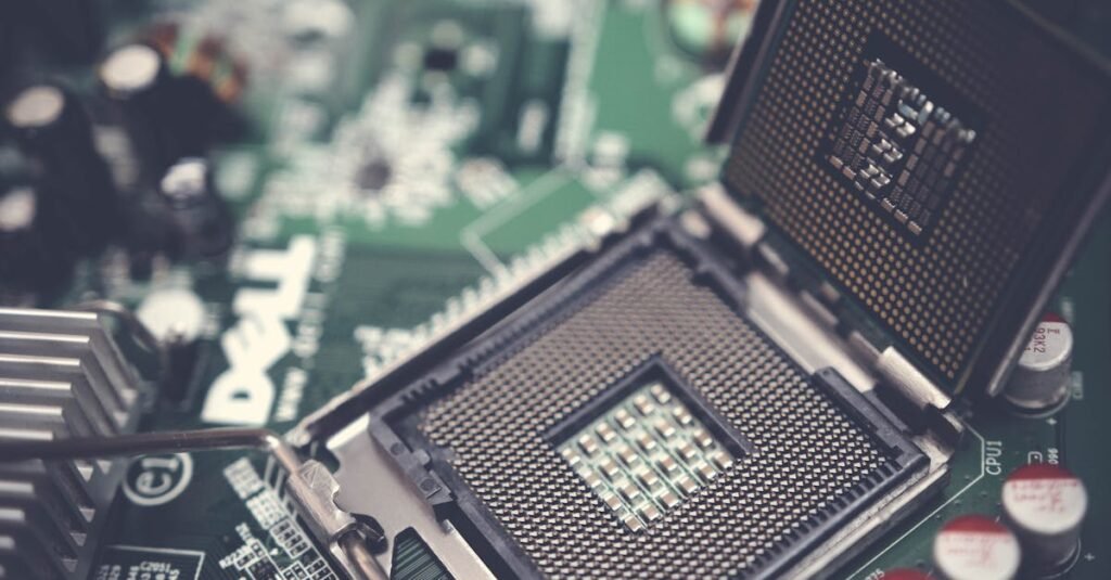 pexels-photo-1432680-1432680 Detailed view of a CPU socket on a green motherboard, showcasing microprocessor technology.